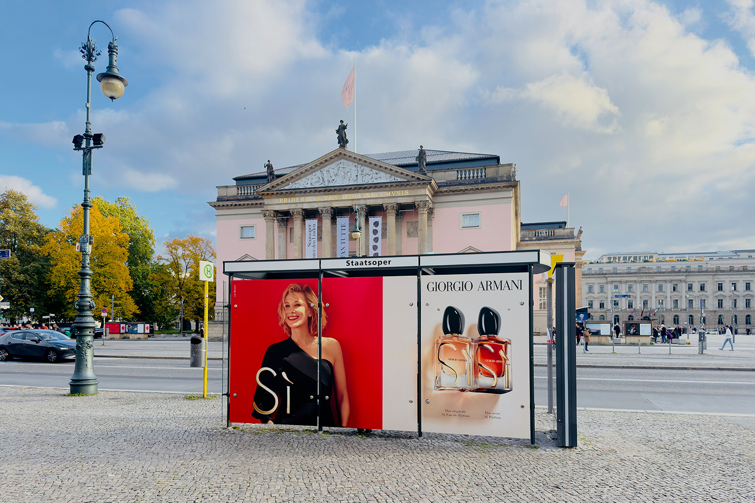 Area Domination entlang "Unter den Linden" in Berlin zeigt Werbung einer Luxusmodemarke an einer Buswartehalle..