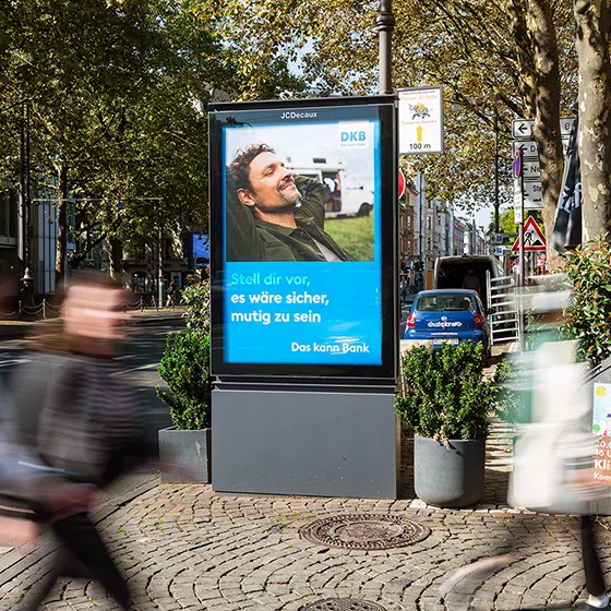 City Light Poster mit Außenwerbung eines Finanzdienstleisters in der Innenstadt von Köln.