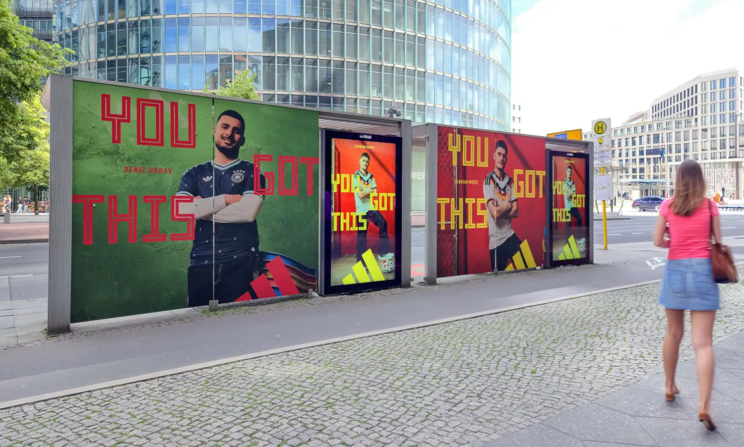 Adidas ads with athletes and "YOU GOT THIS" on a bus stop, a woman walks by.