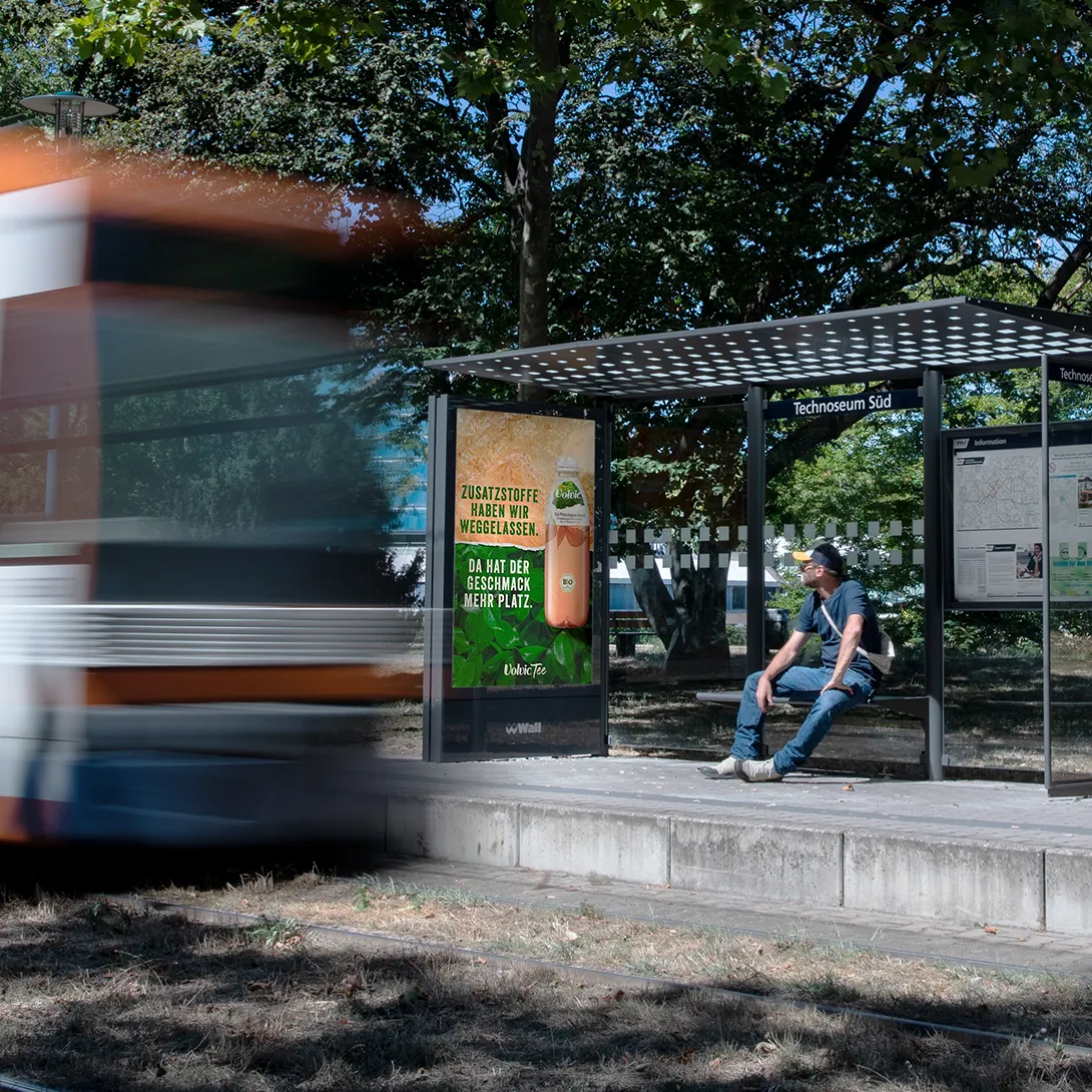 Digital City Light Poster mit OOH-Werbung einer Getränkemarke an Bushaltestelle in Mannheim.