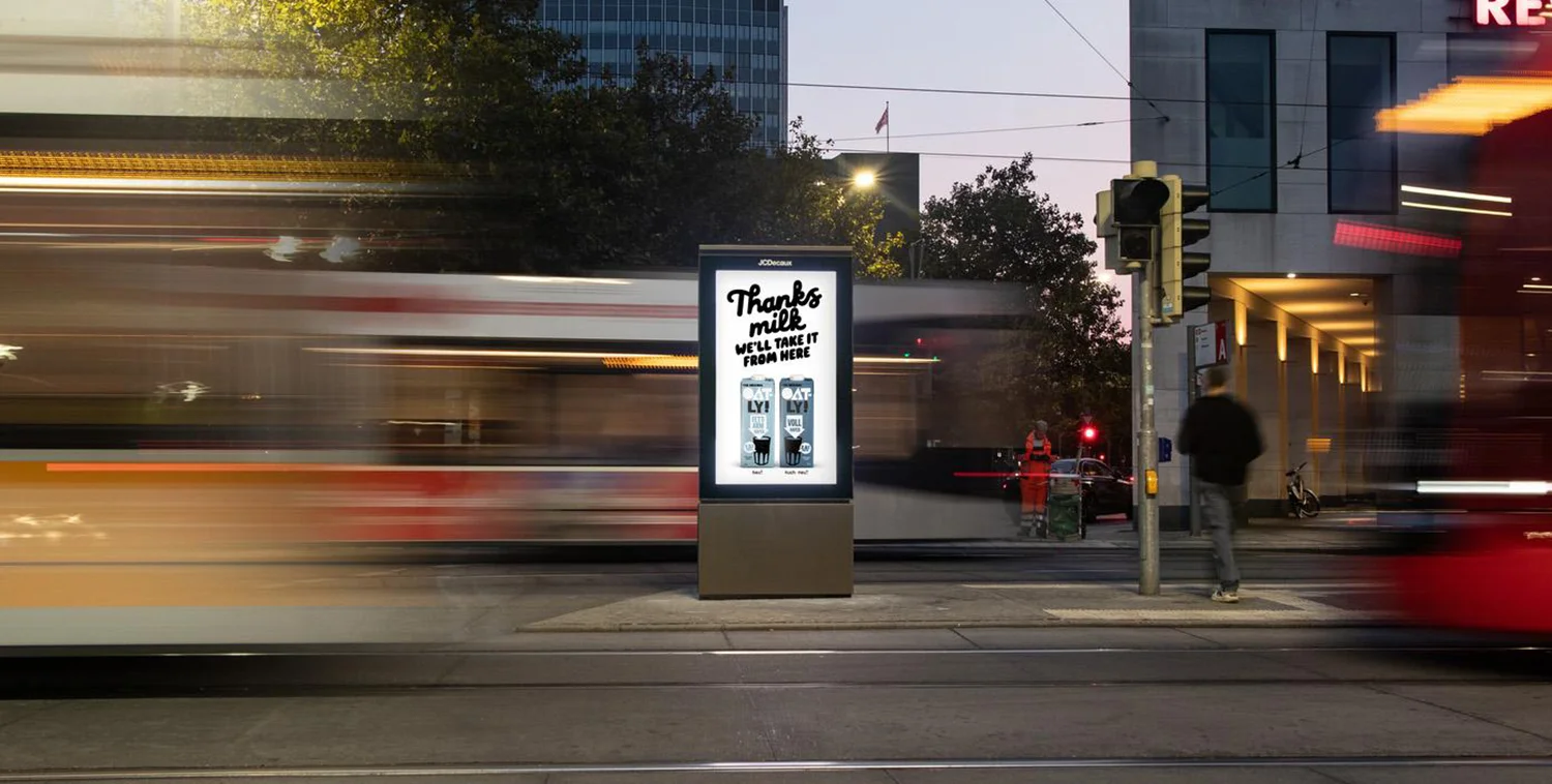 Digital City Light Poster mit Werbung für Hafermilch in Berlin bei Dämmerung
