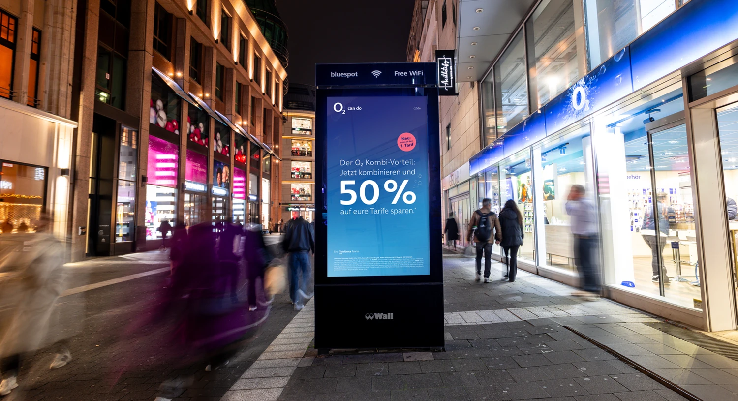 Digital City Light Poster mit Mobilfunkwerbung in Schadowstraße in Düsseldorf bei Nacht.