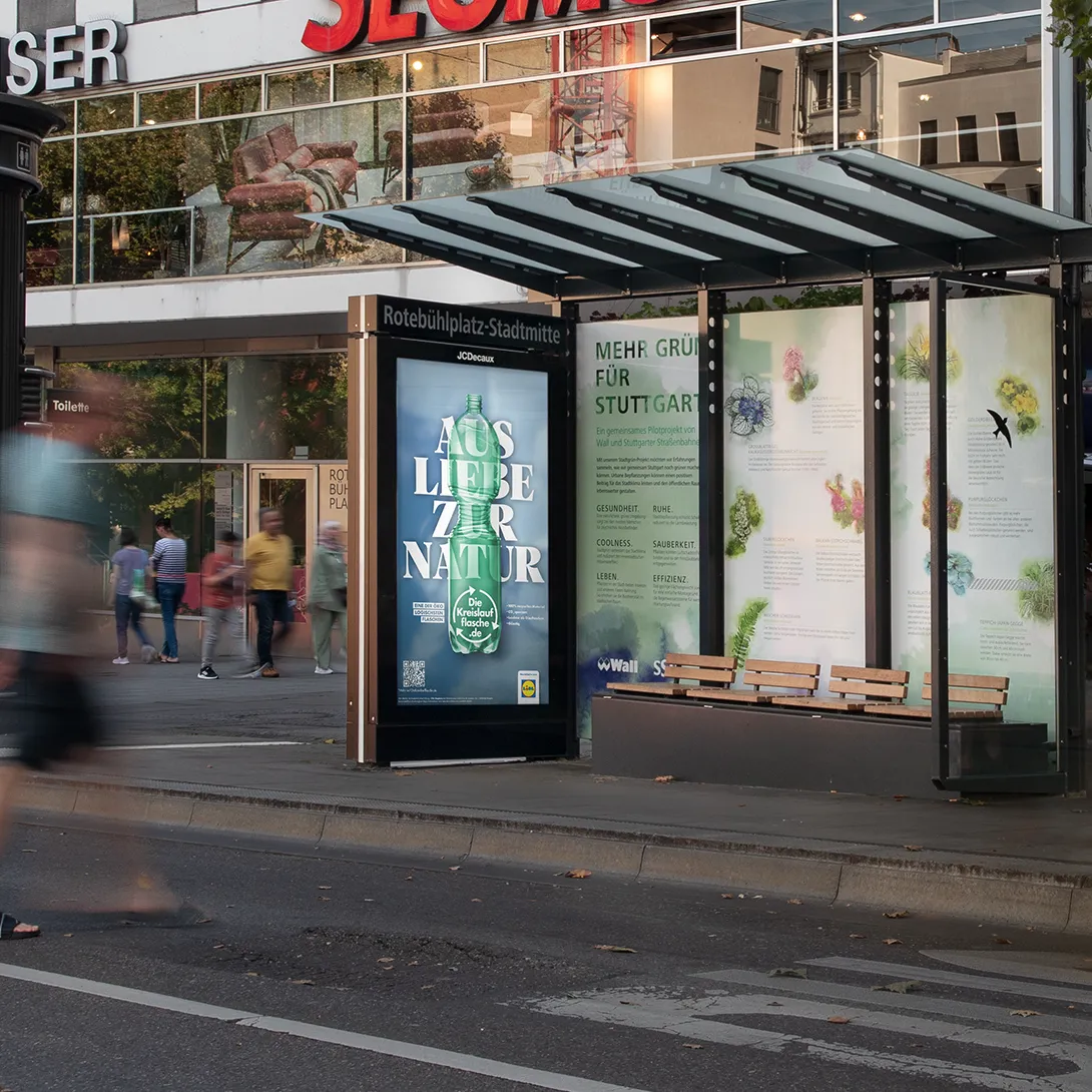 Digital City Light Poster mit Out of Home-Kampagne einer Supermarktkette an einer Haltestelle in der Innenstadt von Stuttgart.