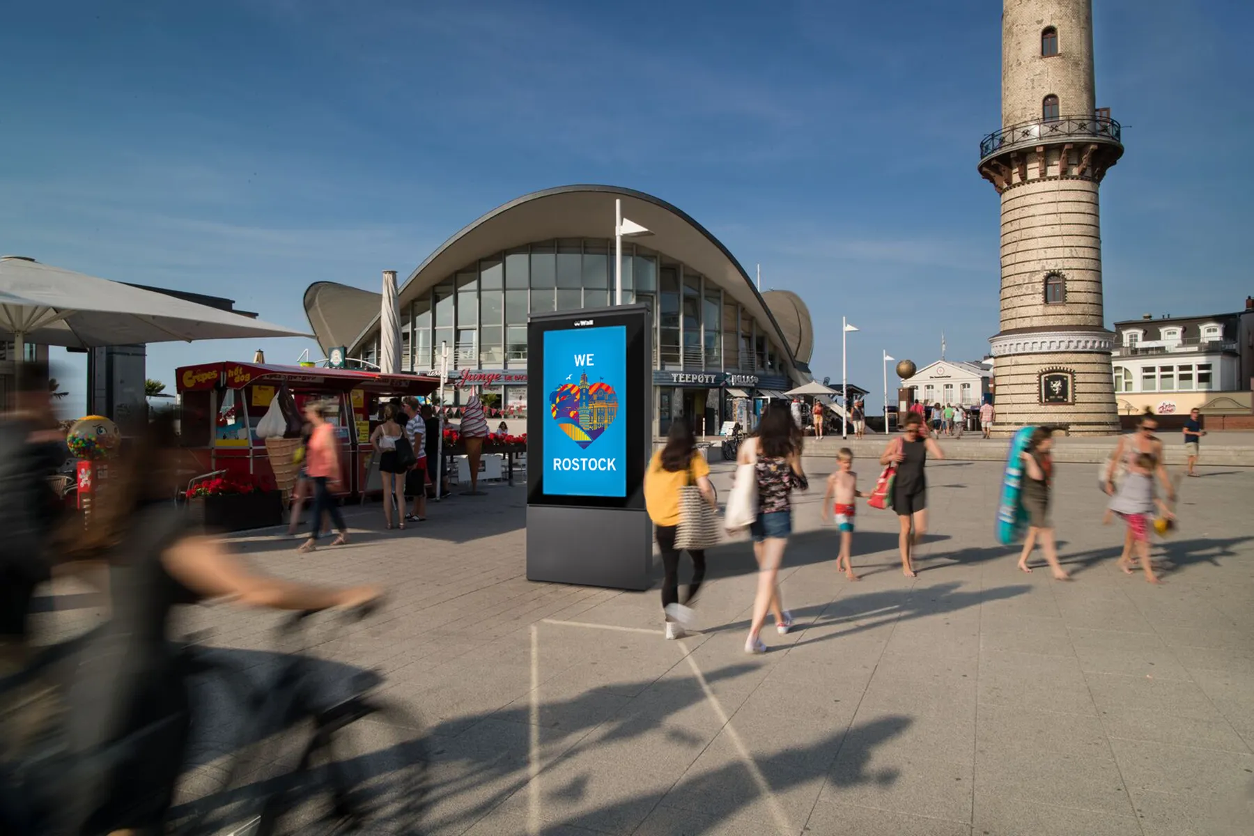 Digital City Light Poster zeigt We Love-Kampagne am Hafen in Rostock-Warnemünde.