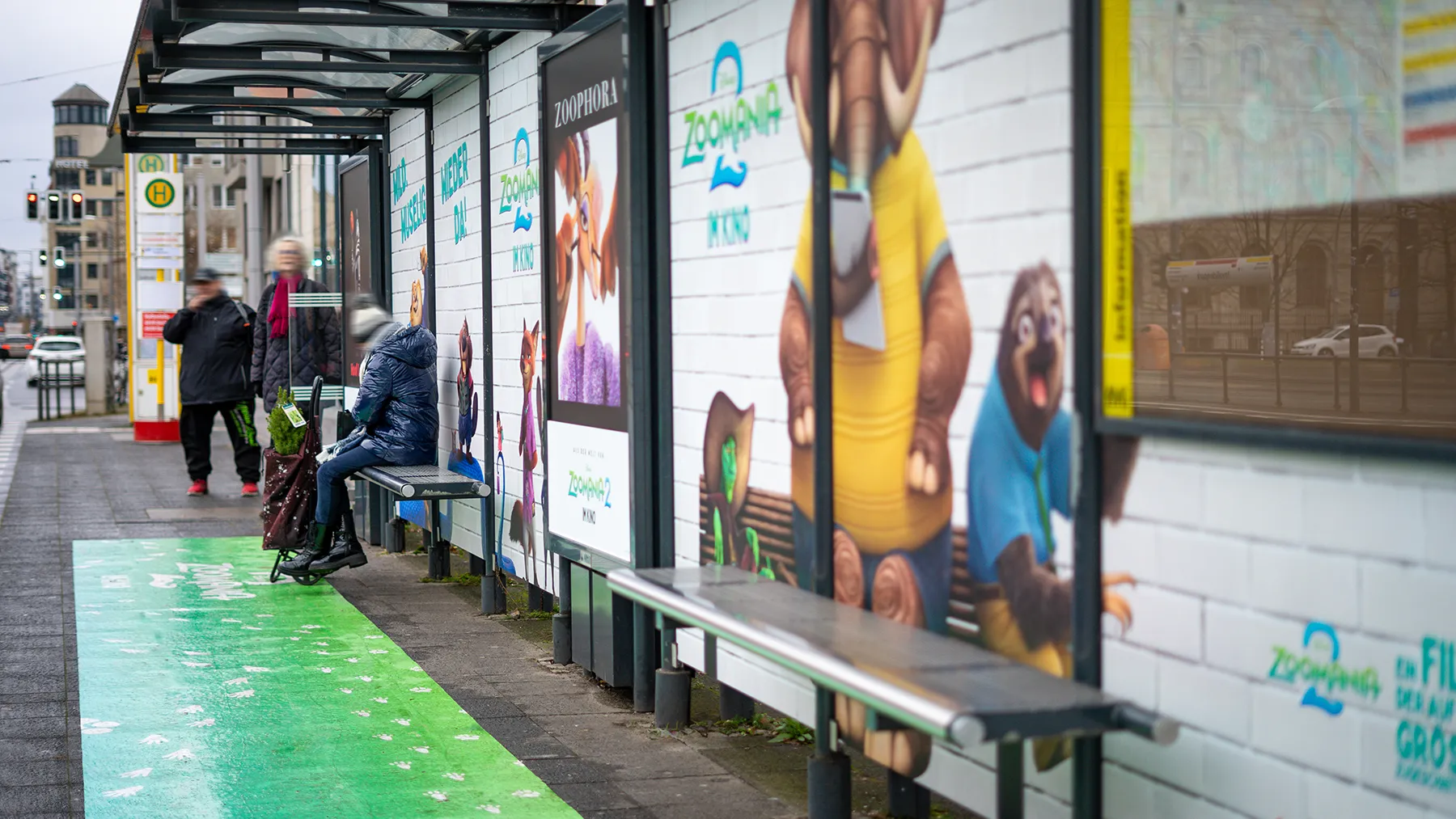Wartehallenbranding mit Floorgraphics an Tramhaltestelle in der Berliner Invalidenstraße zeigt Werbung für einen Animationsfilm.