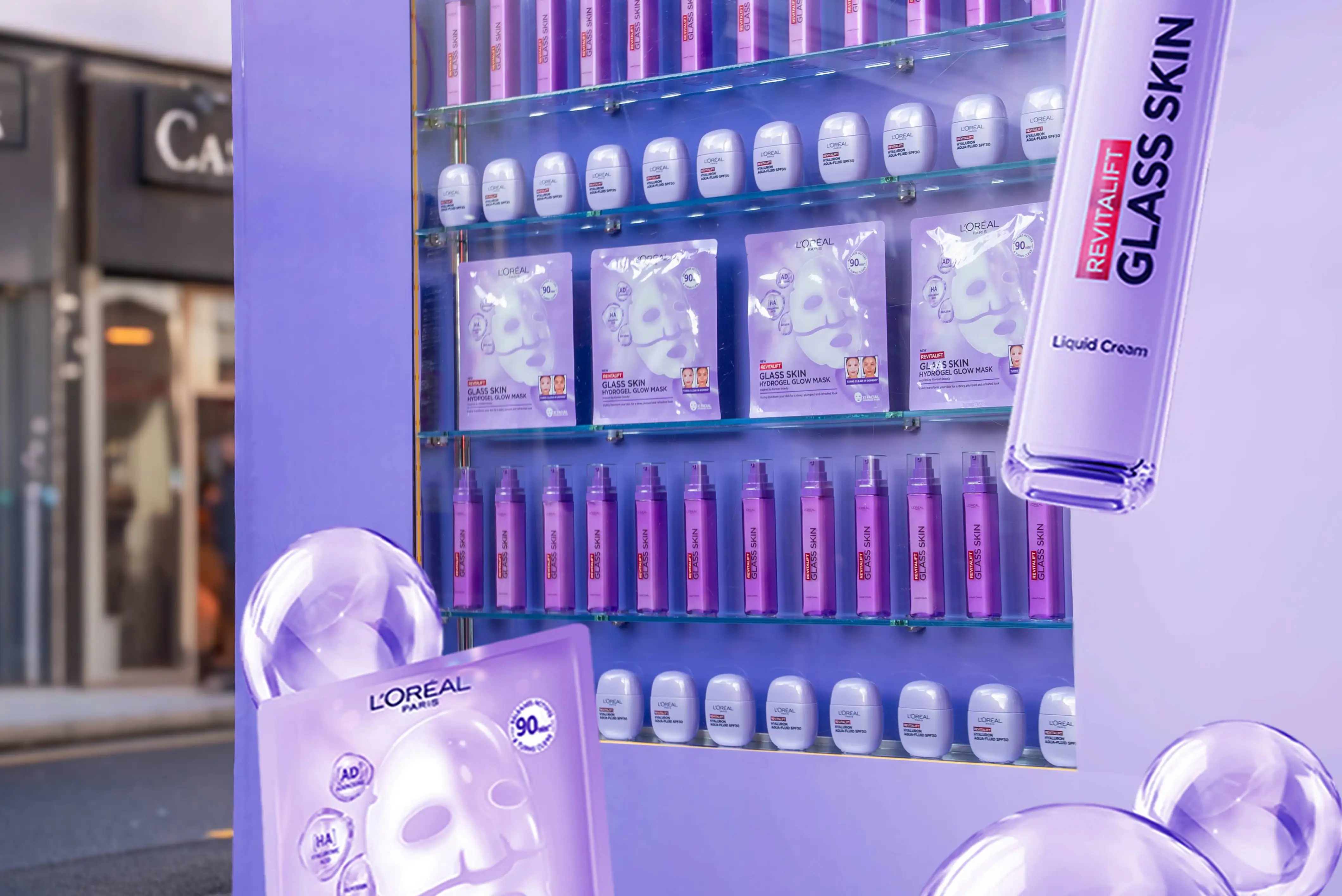 L'Oréal's 'Glass Skin' beauty products displayed in a vibrant purple street vending machine.
