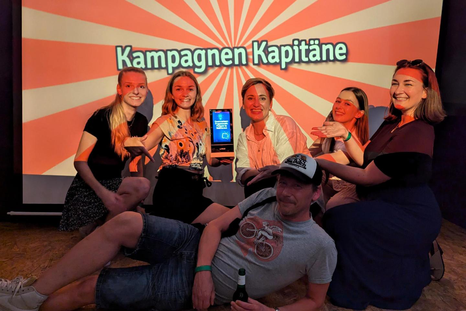 Gewinner-Team des ersten WallDecaux Premium Programmatic Pubquiz posieren für Gewinnerfoto und halten Mini-DCLP-Trophäe.