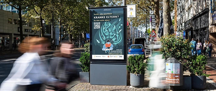 City Light Poster mit Suchthilfewerbung in Kölner Innenstadt an einer Straße.