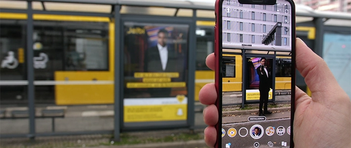 Bild vom virtuellen Filter-Erlebnis auf einem Smartphone von einer social media app  an einer Berliner Tram-Wartehalle.
