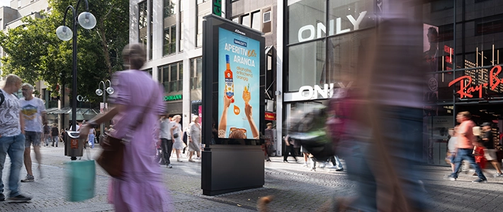 Digital City Light Poster mit alkoholfreier Aperitif-Werbung in belebter Kölner Schildergasse im Sommer.