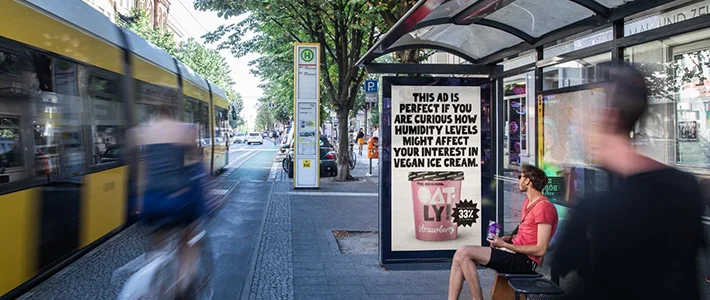 Digital City Light Poster in Bus-Wartehalle zeigt Werbung für veganes Eis.