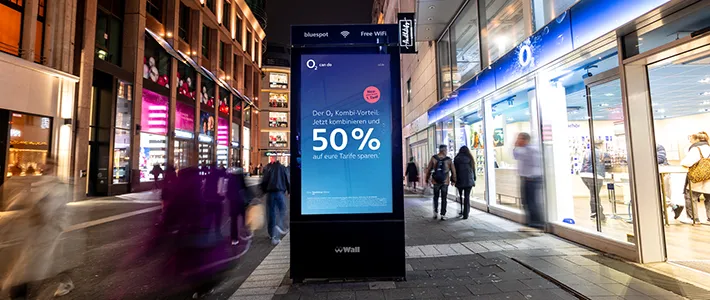 Digital City Light Poster mit Mobilfunkwerbung in Schadowstraße in Düsseldorf bei Nacht.