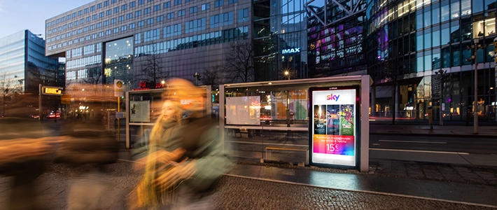 Digital City Light Poster in Buswartehalle zeigt Werbung für Streamingdienst am Potsdamer Platz in Berlin bei Nacht.