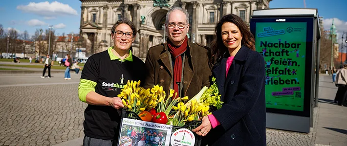 Katharina Mölter, Gründerin foodsharing Moabit, Patrick Möller, Geschäftsführer Wall, und Katharina Roth, Geschäftsführerin der nebenan.de Stiftung feiern die Enthüllung der Kampagne zum Tag der Nachbarschaft 2026.