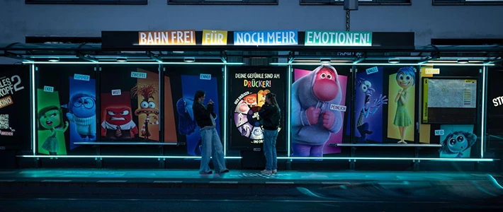 Tram-Wartehalle in Berliner Invalidenstraße leuchtet mit einer farbenfrohen Filmkampagne für einen Animationsfilm in der Nacht.