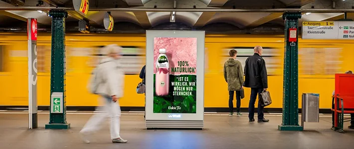 City Light Poster zeigt Getränkewerbung in Berliner U-Bahnhof.
