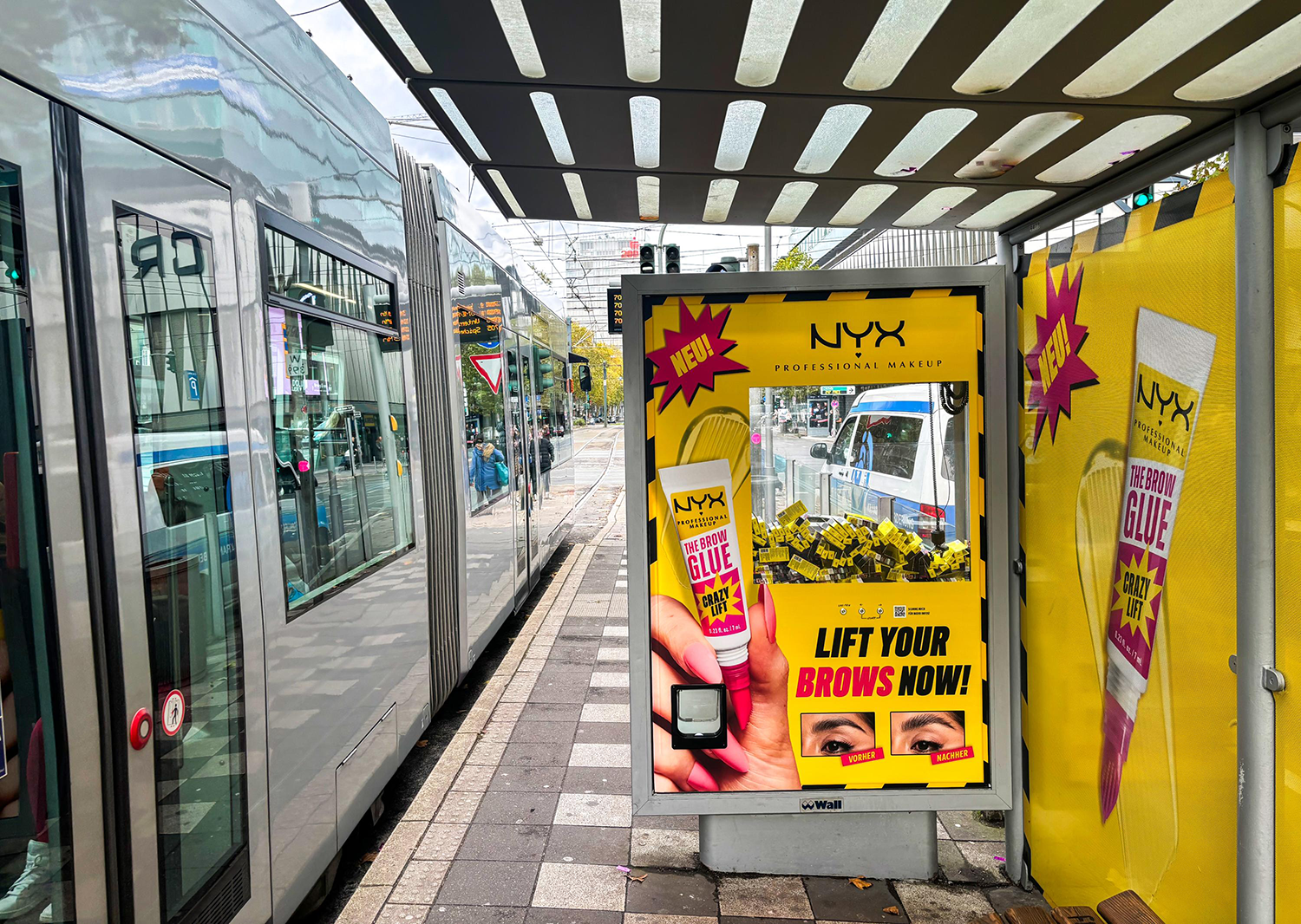 Wartehallenbranding mit Greifarmautomat zeigt in Düsseldorf Werbung einer Kosmetikmarke.