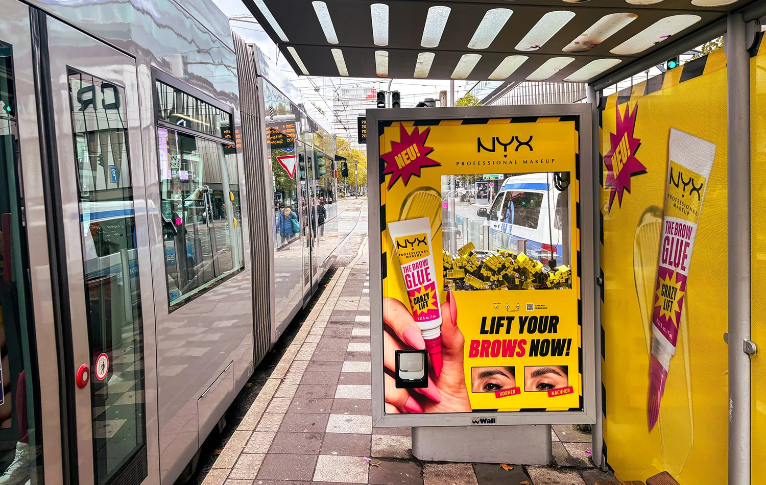 Wartehallenbranding mit Greifarmautomat zeigt OOH-Werbung einer Kosmetikmarke in Düsseldorf.